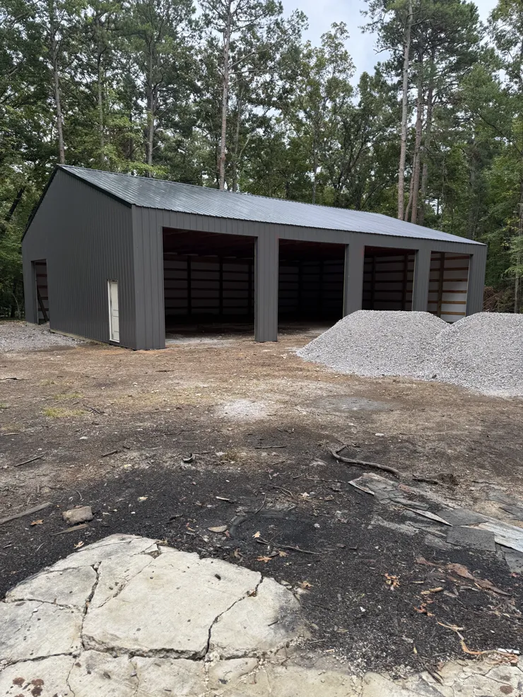 Dark steel post-frame workshop with open bays
